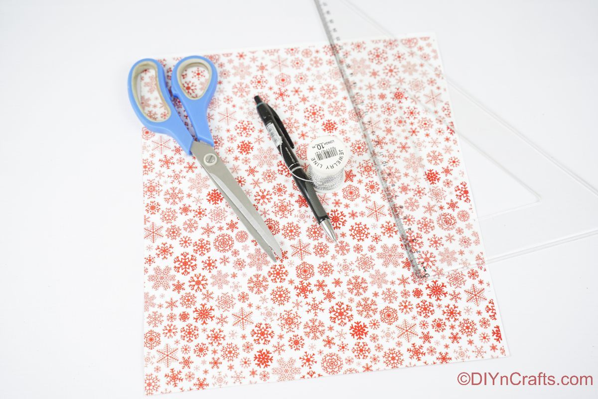 красные и белые ножницы для бумаги для вырезок и ручка на белом столе