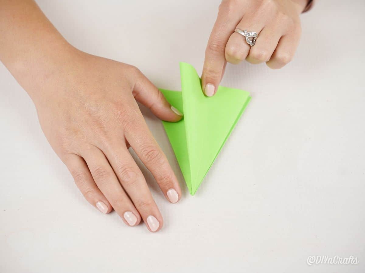 руки складываются на зеленой бумаге