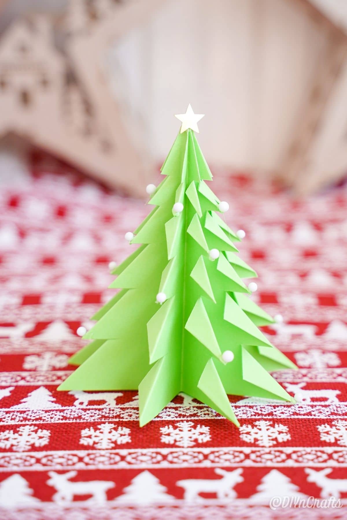 елка из зеленой бумаги на красной и белой праздничной бумаге