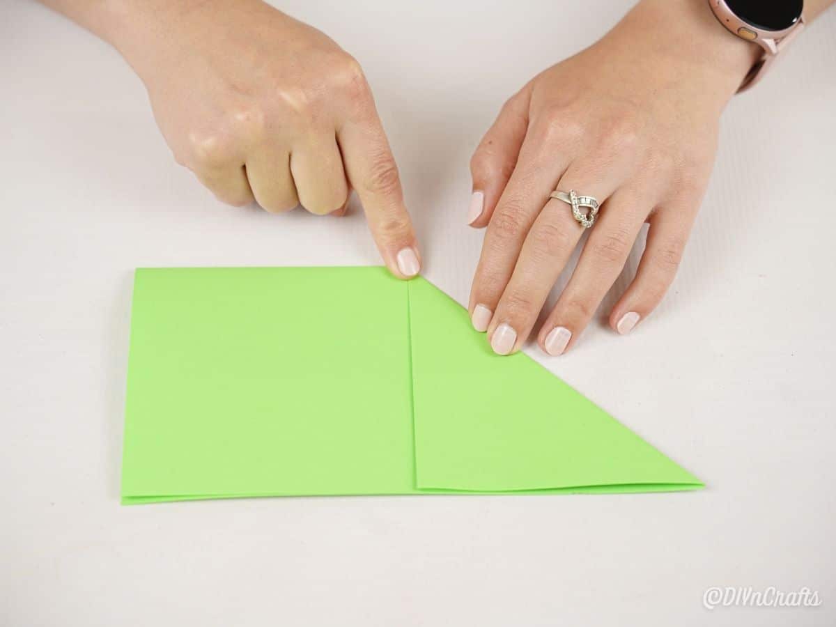 руки создают бумажный треугольник