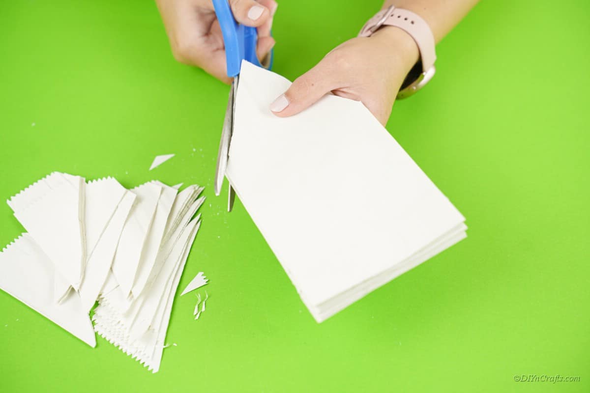 ножницы разрезают белый бумажный пакет 