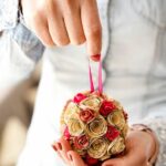 Женщина держит бумажный шар из роз