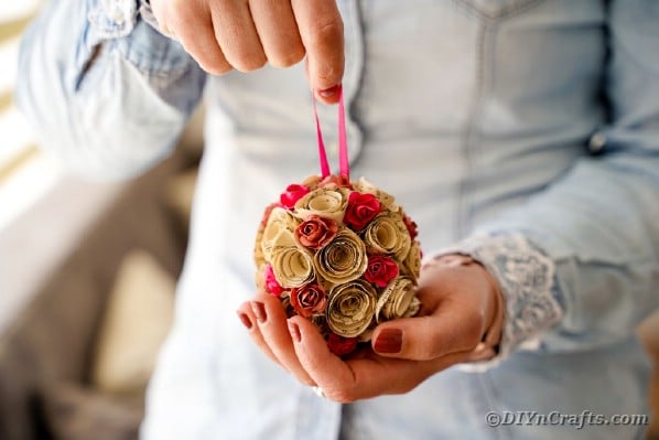 Женщина держит бумажный шар из роз