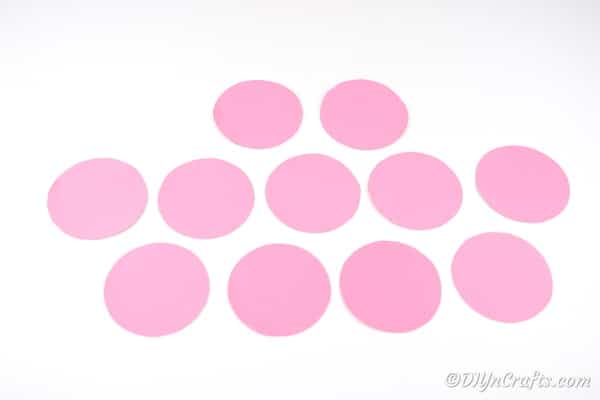 Несколько кругов розовой бумаги на белой поверхности