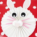 Бумажный кролик на красно-белом фоне в горошек