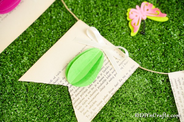 Зеленое 3D яйцо на баннере страницы старой книги на траве