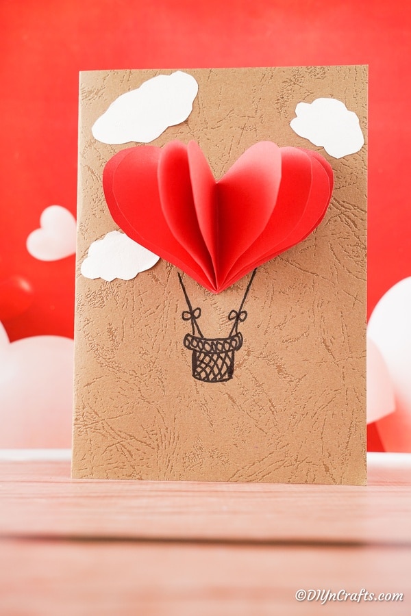 Воздушный шар 3D открытка на день святого валентина сидит на столе с красным фоном